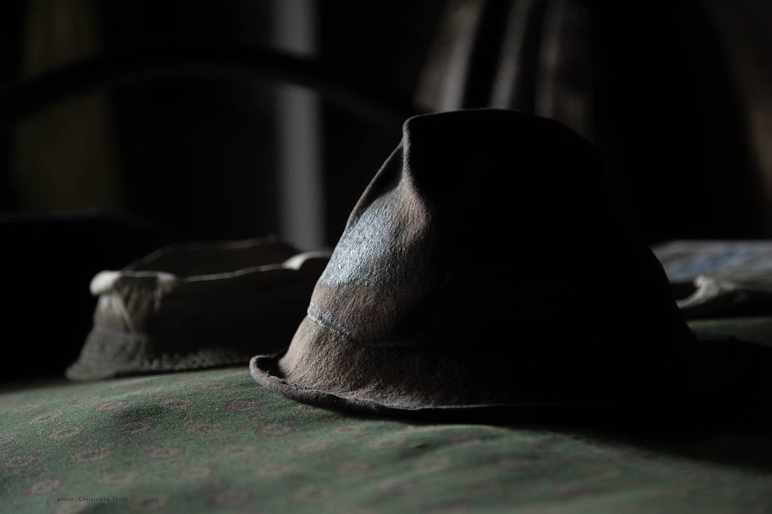 Le chapeau du Claudius photo réalisé dans la ferme de Claudius Jomard et tirée du film Là où le temps s'est arrêté. Un chapeau posé sur un lit et qui porte dans son usure des années de saisons et de travail. Photo de Christophe Tardy photographe à Lyon et en région Auvergne Rhône Alpes